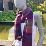 Damessjaal in warme paarstinten en structuursteken